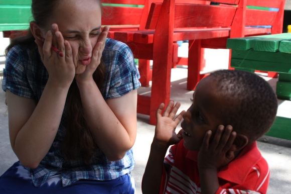 Abby Fleischer speaks a universal language - funny faces - with a child at New Life.