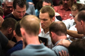 At a meeting in Asia, young missionaries surround new IMB President David Platt to pray for him as he seeks to mobilize churches. Photo by Hugh Johnson/IMB